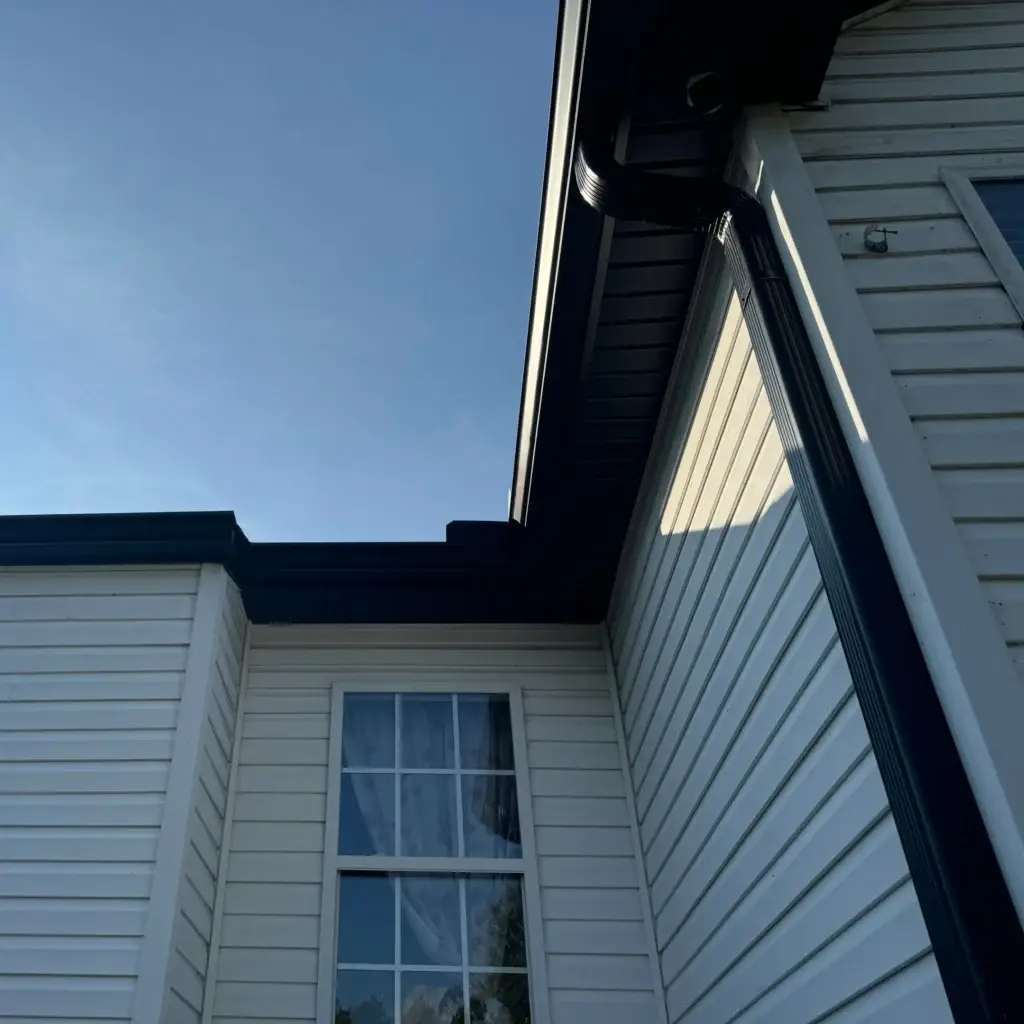 Black gutter installation, complementing exterior home colors and style.