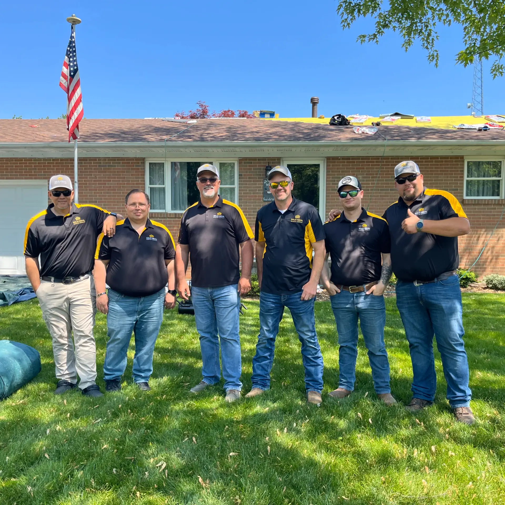 Gold Medal Roofing's Toledo team proudly standing beside their expertly installed roof, delivering top-notch roofing solutions to Northwest Ohio homeowners.